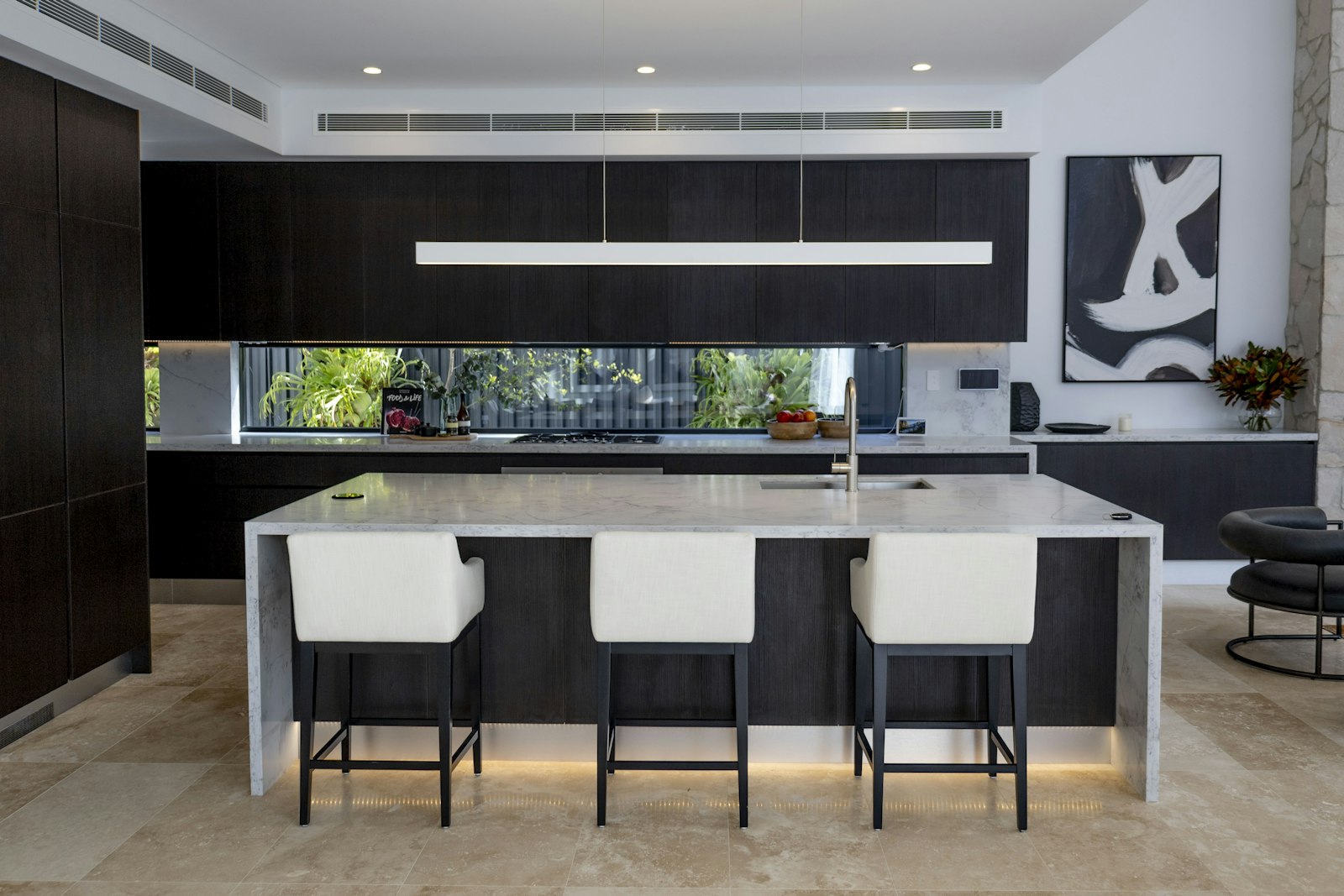 Cocina de líneas nobles con isla y materiales premium en una vivienda de la zona alta de Barcelona